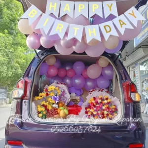Happy birthday car trunk surprise with purple balloons, flowers and stuffed toys